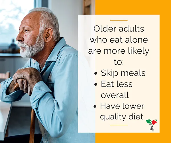 Elderly man with a cane sitting at the kitchen table